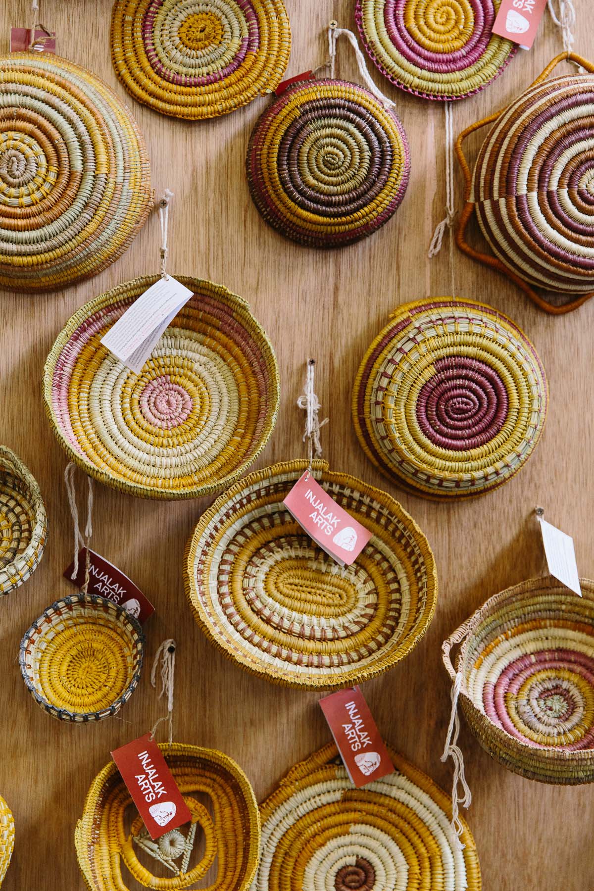 Handwoven baskets hung together on wooden wall at market