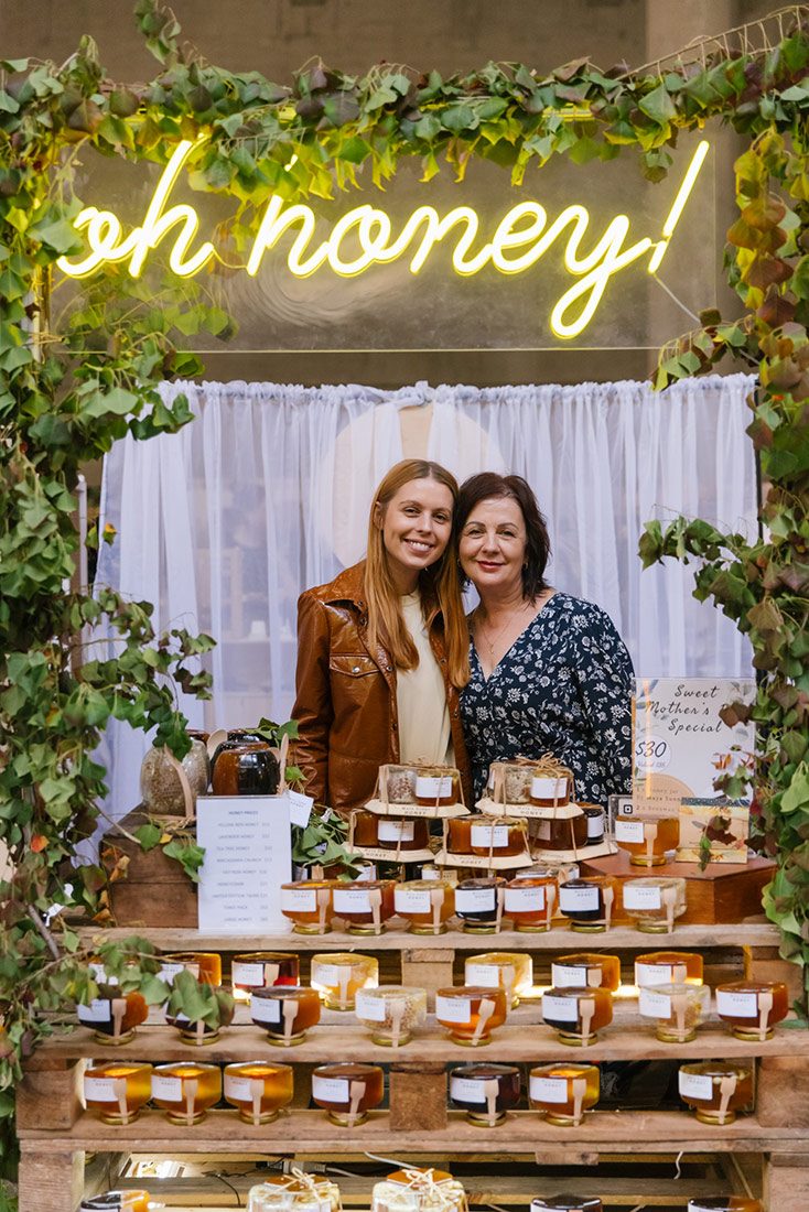 Portrait of mother daughter due at their stand for locally sourced and made honey