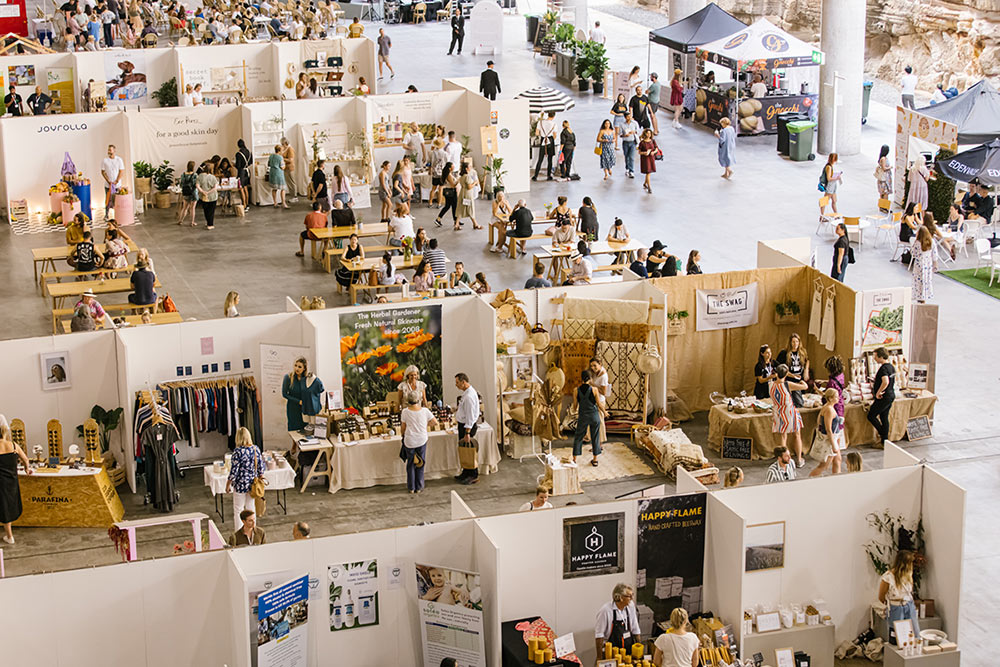 Overlooking the market section of The Conscious Space with attendees dispersed and exploring the stands