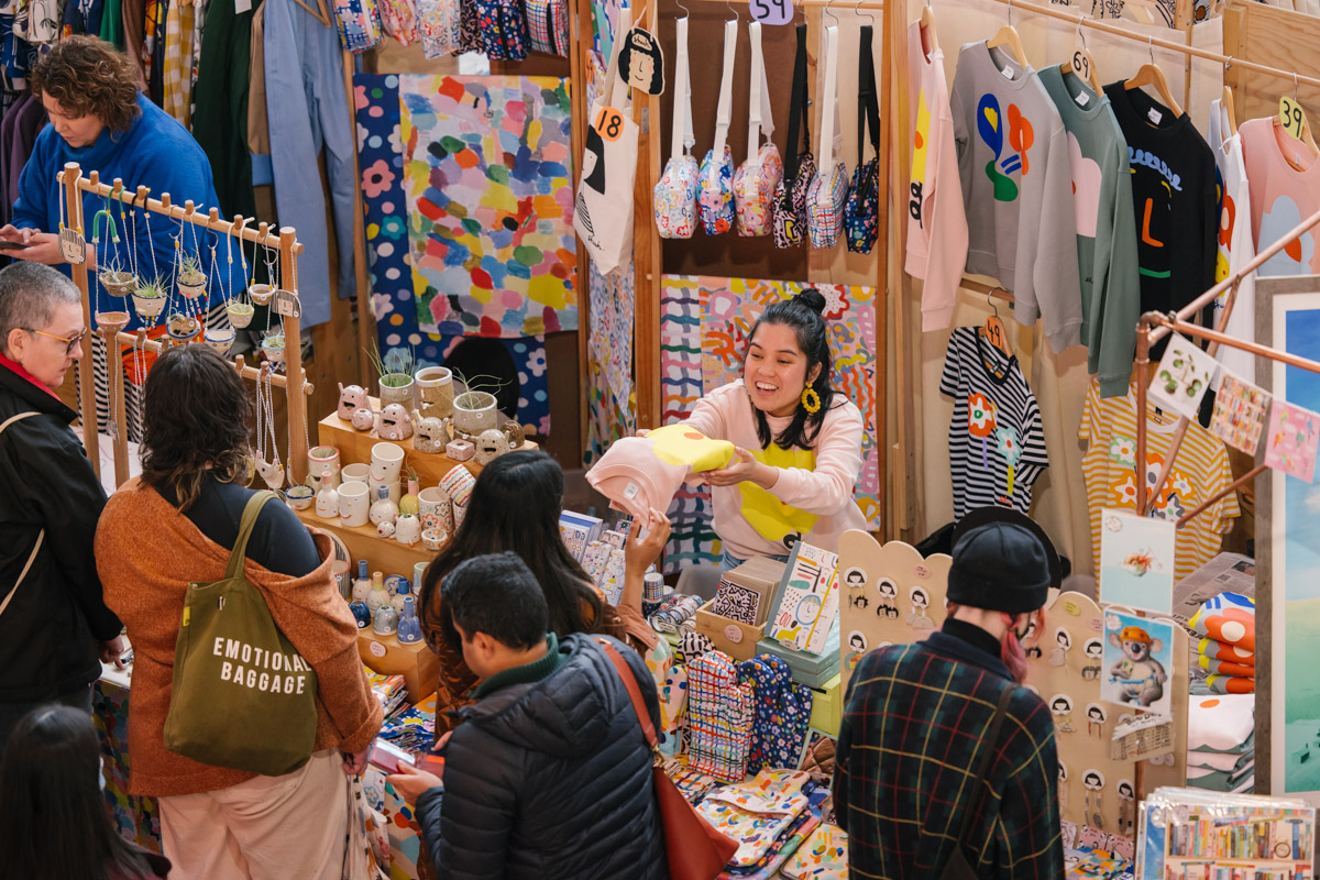 Market goers are served at stands full of colourful and handmade goods