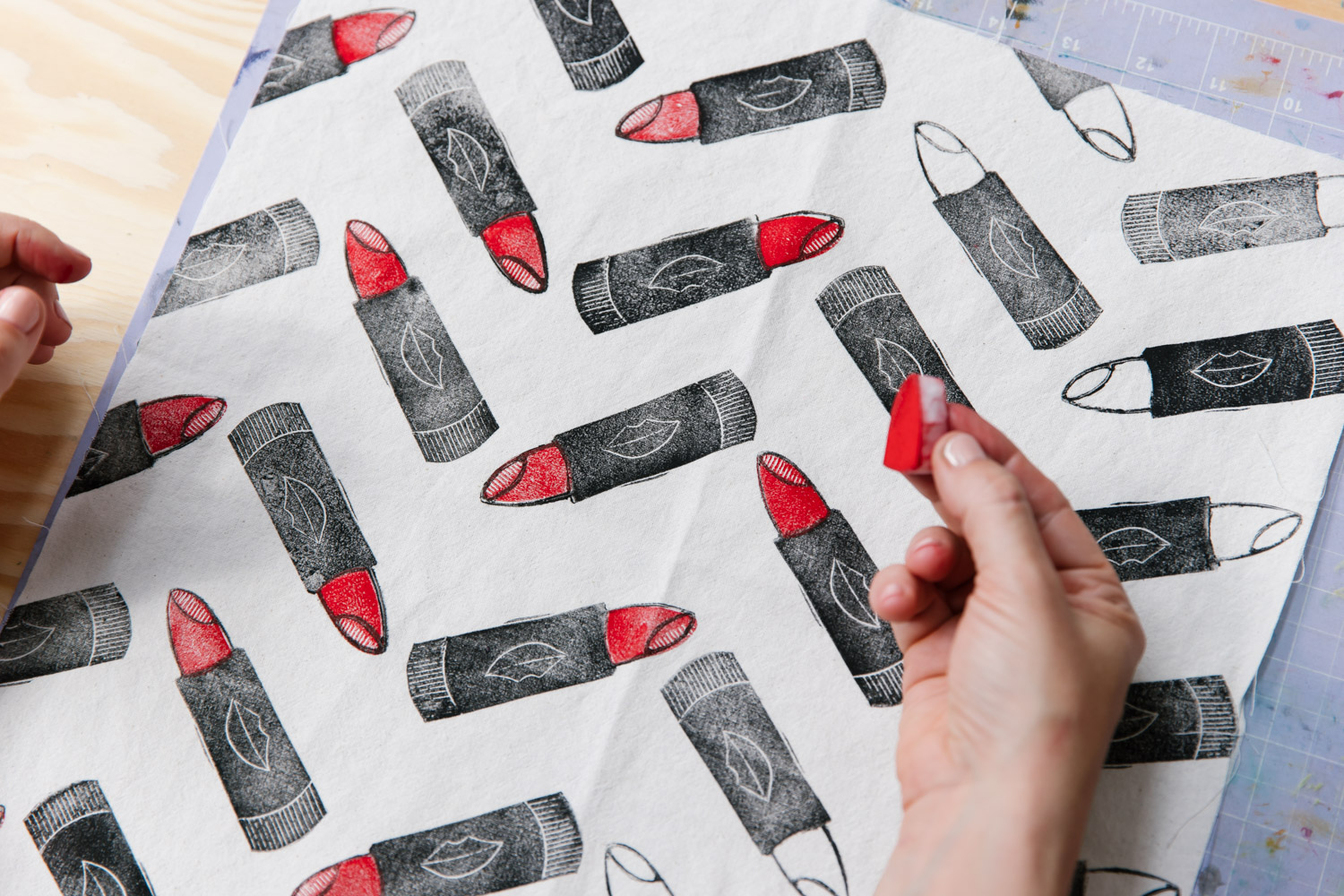 Printing by hand using hand carved rubber stamps onto fabric in the design of lipstick