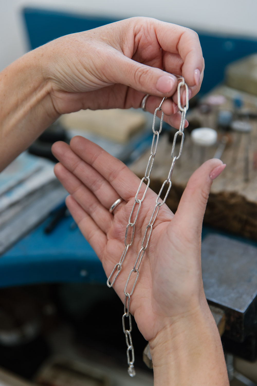 Jeweller inspects a sterling silver chain necklace in their two hands