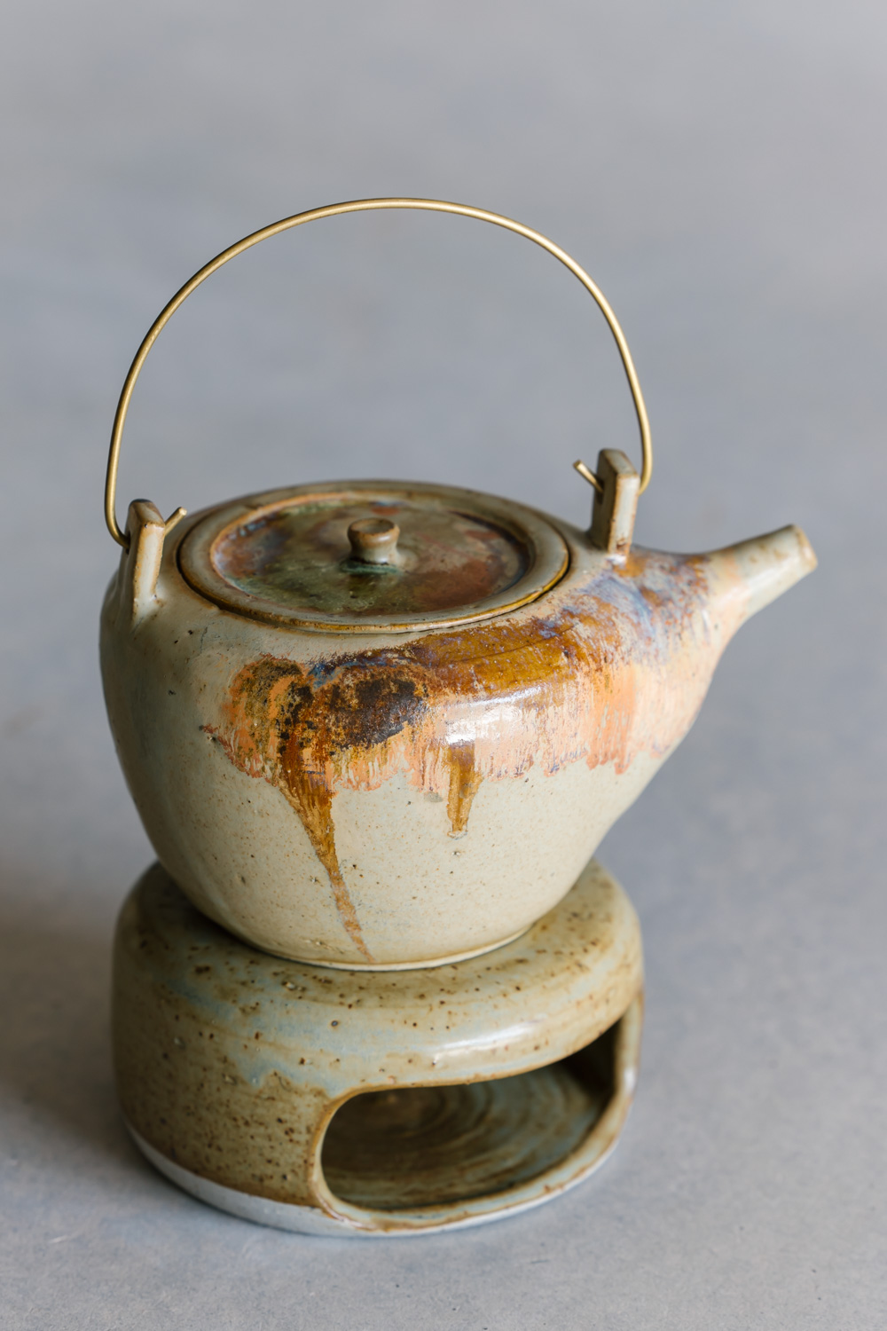 Ceramic teapot with brass handle and teapot warmer