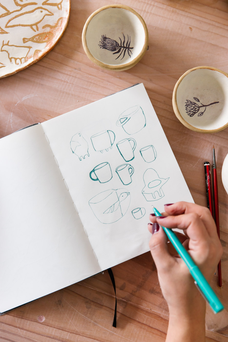 Ceramic artist illustrates ideas in a notebook